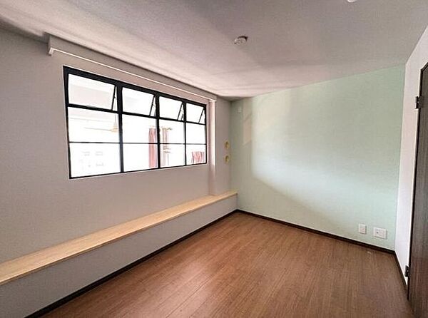 柔らかな光が差し込む、居心地の良いお部屋。壁の一部に配された優しいグリーンが、安らぎとくつろぎを与えます。大きな窓と高い天井により、開放感があり、ゆったりと過ごせる空間です。