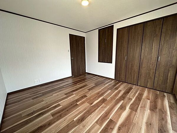 壁一面に設置された大型のクローゼットが特徴的な洋室。衣類や日用品をたっぷりと収納できるため、お部屋をすっきりと保ちやすく、家具の配置もスムーズに行える実用的な設計です。