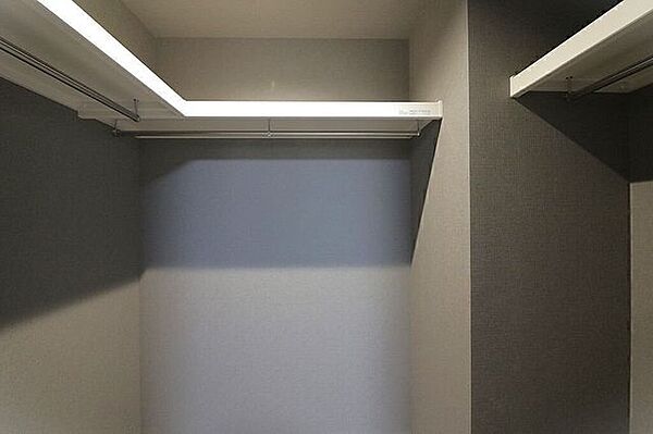 グレーの壁紙が静けさと高級感を演出するモダンなトイレ空間。清潔感のあるホワイトの便器が壁面の色調と美しく調和しています。