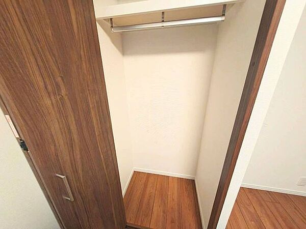 お部屋のフローリングと調和する木目調の扉を採用した収納スペースです。内部にはハンガーパイプを設置しており、衣類を整理して掛けられるため、居住空間をより広々と活用できます。