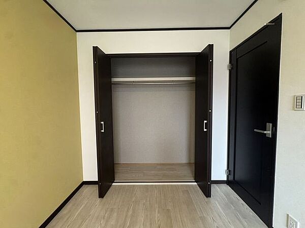 ハンガーパイプと上部棚を備えた、間口の広い便利なクローゼット。丈の長い衣類から小物まで分類してまとめて収納できます。両開きの折れ戸仕様で中の荷物が見渡しやすく、毎日の出し入れもスムーズです