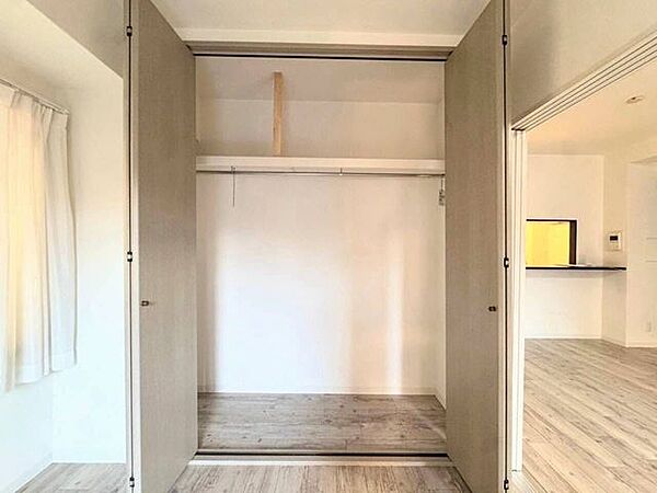 折れ戸が大きく開き、物の出し入れがスムーズな大型クローゼット。ハンガーパイプと上部棚を備え、衣類から季節物の大きな荷物まで効率よく整理できます。お部屋の物をすっきり収め、生活空間を広く使えます。