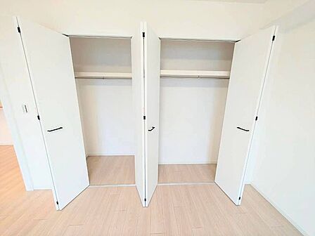 ハンガーパイプと上部棚を備えたクローゼット。丈の長い服もシワにならず掛けられ、上の棚には季節外の荷物をすっきり収納できます。