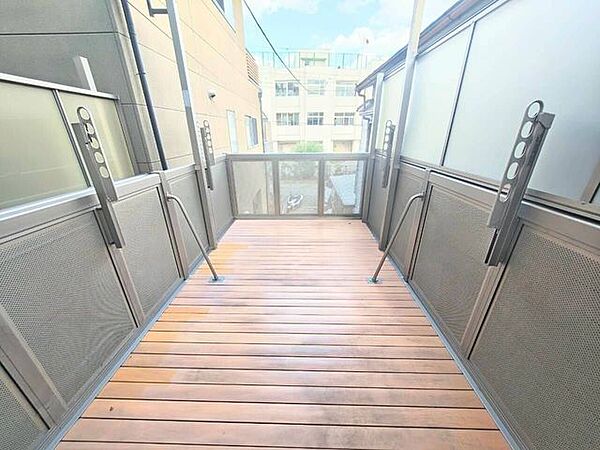 足元に温かみのあるウッドデッキを敷き詰めた、奥行きのあるバルコニー空間です。空を見上げられる開放的な屋外スペースで、心地よい風を感じながら気分転換ができます。