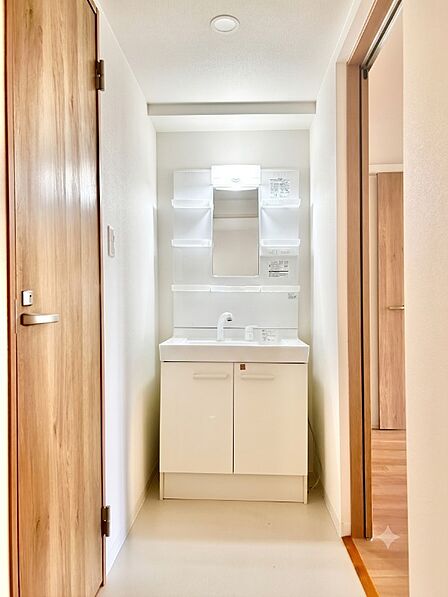 パッと明るいホワイト基調の洗面化粧台!鏡の左右にはスキンケア用品などをサッと手に取れる便利な小物トレイを配備。広い洗面ボウルと下部収納も備え、忙しい朝の身支度もスムーズに行える清潔感ある洗面室です。