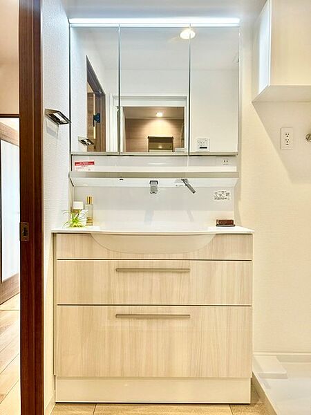 明るく清潔感あふれる三面鏡付きの洗面化粧台！鏡裏収納と下部のスライド引き出しで小物や日用品をすっきり整理できます。水栓まわりがお手入れしやすいスッキリとしたデザインで、朝の身支度も快適です。