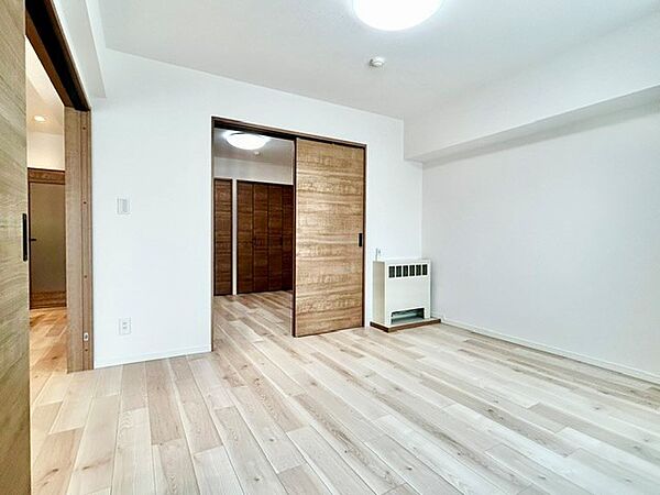 引き戸を開放すれば隣室と繋がり、フレキシブルに使える洋室！温かみのある木目調のドアとナチュラルなフローリングが爽やかな空間を演出します。暖房器具も完備され、一年中快適に過ごせる居室です。