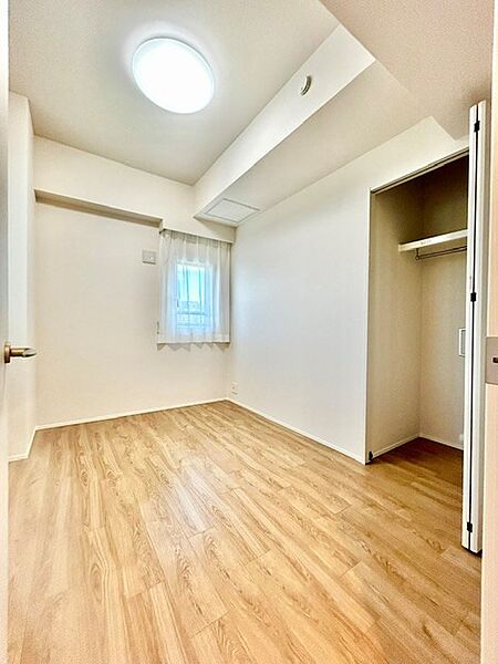 ハンガーパイプを備えたクローゼット付きのシンプルな洋室！衣類をしっかり収納でき、お部屋をすっきり保てます。温かみのある木目調フロアと白を基調とした壁面が爽やかな印象を与える落ち着いた居室空間です
