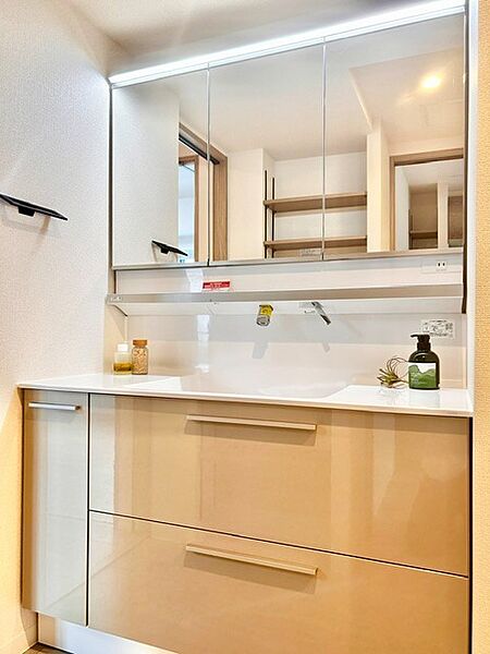 明るいLED照明付きの三面鏡を備えたスタイリッシュな洗面化粧台！水栓まわりに水が溜まりにくい壁付け水栓で清潔を保てます。鏡裏収納やスライド引き出しなど収納も豊富で、朝の身支度も快適に行えます。
