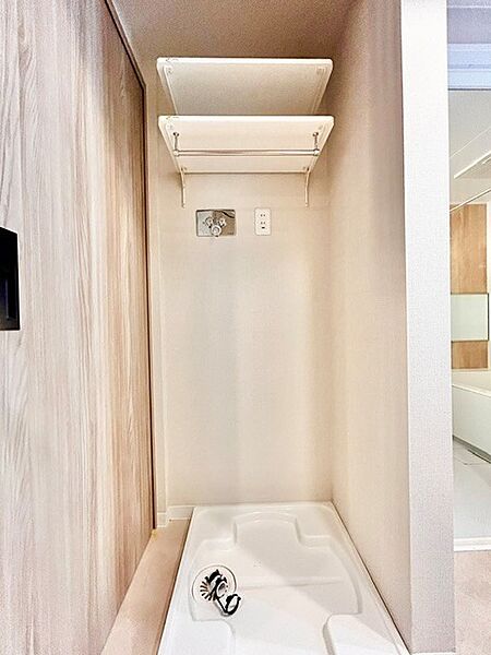 上部に便利な可動棚とハンガーパイプを備えた清潔感のある洗濯機置き場！洗剤類やランドリーグッズをすっきり整理でき、家事動線もスムーズです。防水パン設置済みで、機能的かつ使い勝手の良い空間です。