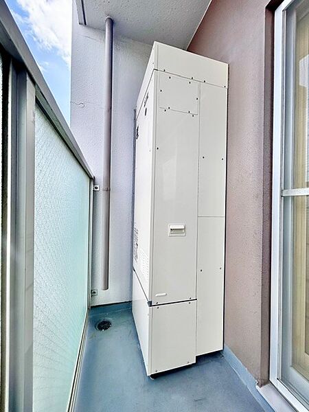 バルコニーに設置された新品の灯油ボイラー（給湯・暖房設備）。新品ならではの安心感とともに、冬場の寒い季節も快適なお湯やお部屋の暖かさをしっかり支えます。日々の暮らしを快適にする頼もしい設備です。