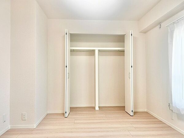 ハンガーパイプと上部棚を備えた壁一面の大容量クローゼット！衣類を掛けたままたっぷり収納でき、上段にはバッグや季節物の小物を整理できます。折れ戸仕様で開口部が広く、物の出し入れもスムーズです。