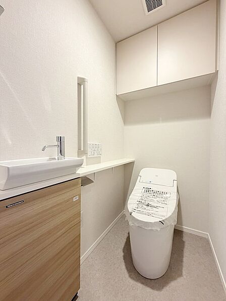 【トイレ】手洗い付きのトイレ。収納棚付きで使いやすい仕様。温水洗浄便座で快適にお使いいただけます。