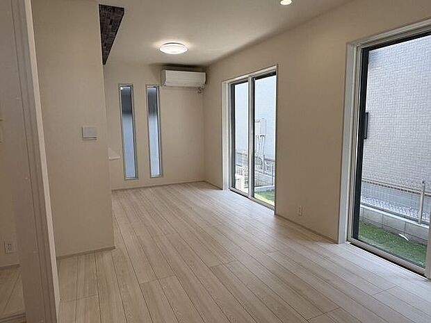 大きな窓から心地よい光が差し込む、明るいリビング。ナチュラルな色合いのフローリングが、空間全体にやわらかな印象を与えています。家族が集まり、日々の暮らしを穏やかに過ごせそうな寛ぎの空間です。