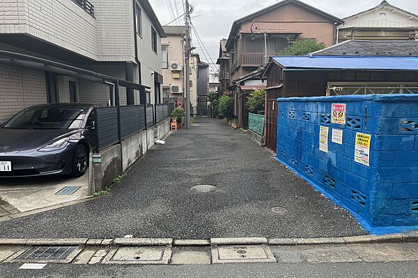 物件の北西側前面道路（南西側から）。前面道路は私道で、周辺居住者と共同管理です。