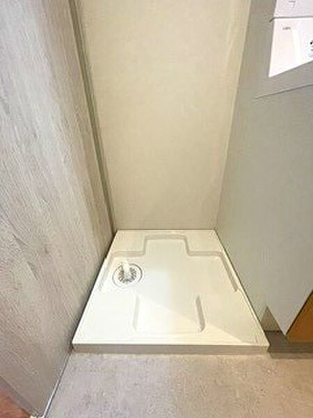 洗濯機置場は室内に確保し、防水パンも新規交換。上部棚には洗剤やタオルを収納でき、限られたスペースを無駄なく使える設計です。
