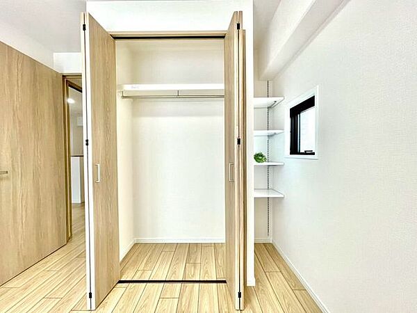 ハンガーパイプと棚を備えた収納。衣類や小物を分けて整理しやすく、室内をすっきり保てます。