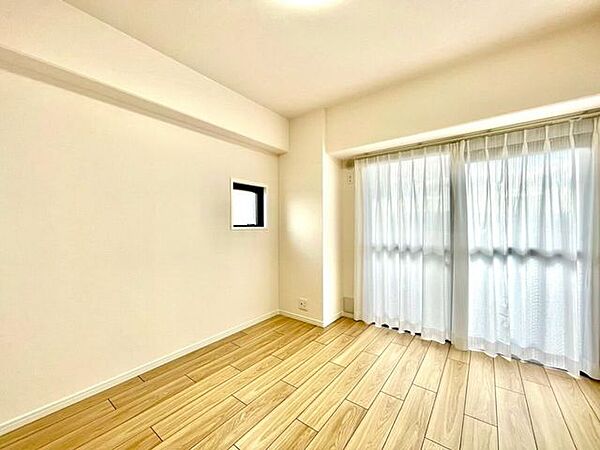 大きな窓から光が入る洋室。明るい木目の床がやさしい印象で、落ち着いて過ごせます。