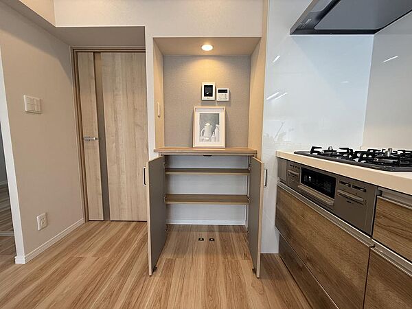 キッチン横には便利な収納棚を設置。食品のストックや調理家電、日用品などをまとめて収納でき、すっきりとした空間を保てます。
