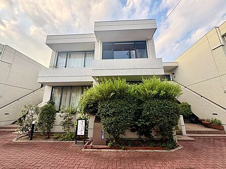閑静な住宅街に佇む、白を基調としたタイル貼りの低層マンション。アプローチには手入れされた豊かな植栽が配され、重厚感と温もりを兼ね備えた洗練された外観が住まい手を優しく迎えます。