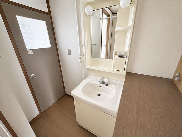 【清潔感のあるシンプルな洗面空間】小物もスッキリ収納！身支度に便利な照明・コンセント付きの洗面化粧台です。サイドや下部に収納スペースを備え、散らかりがちな小物をすっきりと整理していただけます。