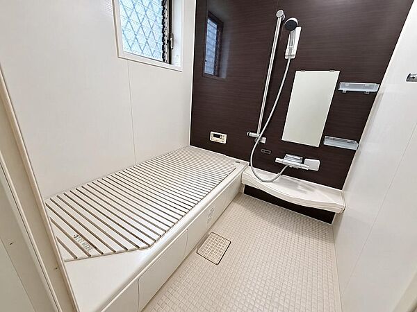【木目調パネルが上質な1坪タイプの癒やしバスルーム】清潔感のある快適なバスルーム。ゆったり足を伸ばせる浴槽と、水はけが良くお手入れしやすい床面を採用。天候を気にせず洗濯物が干せる浴室乾燥機付き。
