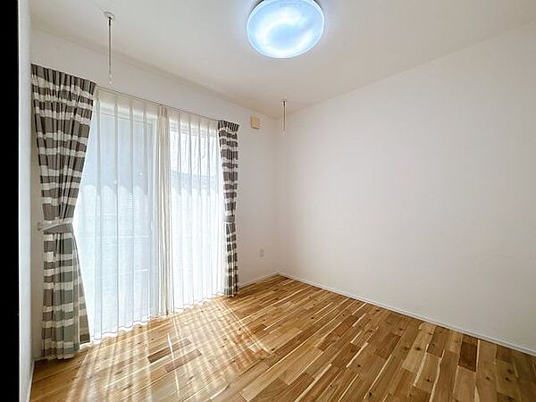 【1階洋室】LDKから続き間になる4.5帖の洋室です。室内干しが出来るよう物干し竿のフックがついています。