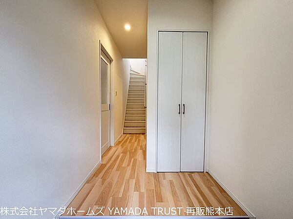 玄関から入ったすぐの廊下の写真です。白い建具と木目調のフロア材で明るい印象に仕上げました。