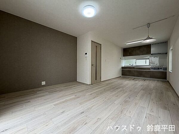 グレーのアクセントクロスと木目調のフローリングが落ち着く約13帖のゆとりある空間です。