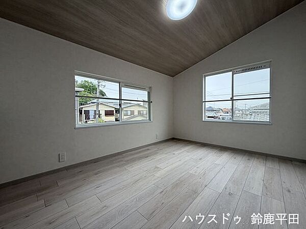 【2階北側約6帖洋室】木目調の勾配天井が印象的な洋室。2面採光で明るく、開放感のある空間です。