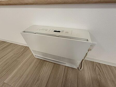 リビングの窓下に設けられた暖房機。白い本体が壁になじみ、寒い季節のくつろぎ時間を支えます。ご家族が集まる空間で、暖かく過ごせるのがうれしい魅力。操作方法や家具との位置関係も、ご見学時にご確認ください。