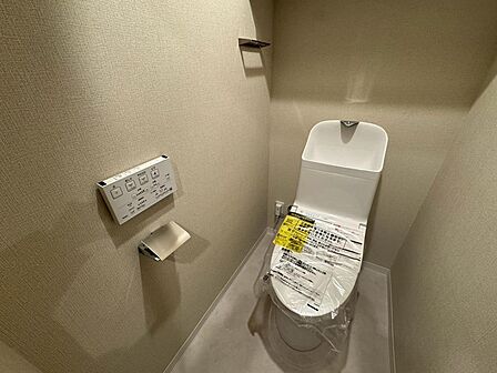 温水洗浄便座を備えた、すっきりとした印象のトイレ!落ち着いた内装で、毎日使う場所を心地よく整えています!壁付けの操作パネルやペーパーホルダーの位置、出入りのしやすさも、ぜひ一度現地でお確かめください!