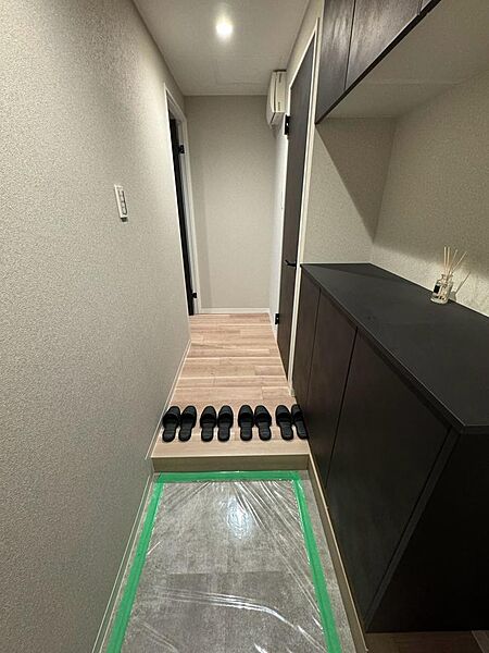落ち着いた色合いでまとめられた玄関。右側には収納が備わり、靴や小物をすっきり片付けられます。廊下へ続く動線もシンプルで、帰宅時や来客時の使い勝手を想像しやすい空間です。収納量は現地でご確認くださいね。