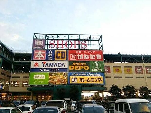 SHOPS 徒歩15分。スーパーマーケットや家電量販店、家具店、大型リユースショップ、飲食店など多彩な店舗が揃っており、1300台収容の無料駐車場を備えています。 1130m