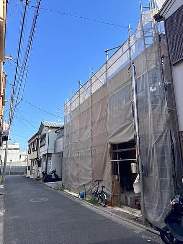 建築中の建物と前面道路を一緒に確認できます。道路の幅や建物との位置関係、周辺の街並みなど、実際に現地を訪れた際の雰囲気をイメージしやすい一枚です。