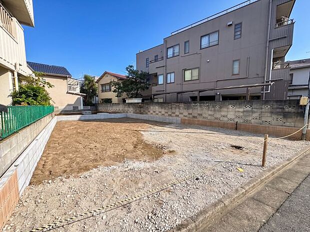 建築前の現地の様子を確認できる一枚。敷地前には道路が整備され、周辺も住宅が建ち並ぶ落ち着いた街並みです。実際の敷地の広さや周辺環境をイメージしやすい写真です。