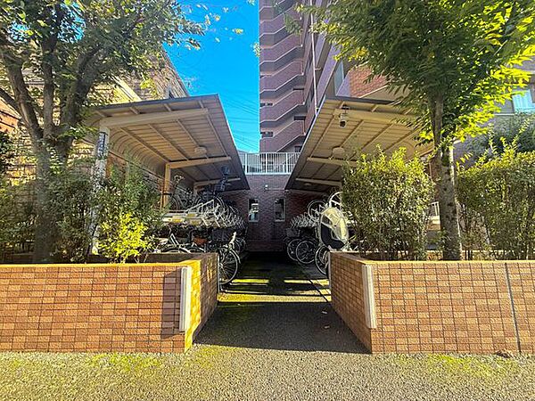 建物周辺には緑豊かな植栽や庭が整えられており、自然を身近に感じられる落ち着いた空間です。レンガ調の囲いも印象的で、マンションの上品な雰囲気を引き立てています。