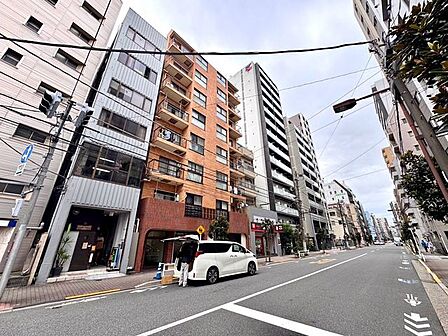 落ち着いた色合いの外壁でまとめられたマンションで、周囲の建物と調和した外観です。前面道路からエントランスへ向かう動線も分かりやすく、すっきりとした佇まいです。