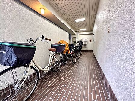 建物内の共用廊下は屋根のあるつくりで、雨の日も移動しやすい空間です。自転車などを置けるスペースもあり、住民が日常的に利用しやすい共用部となっています。