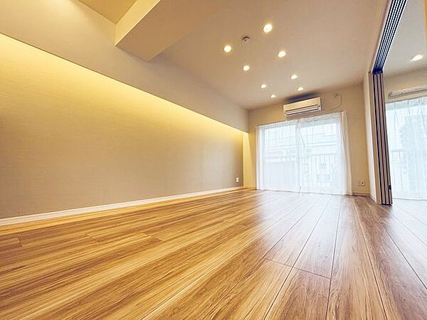 大きな窓から自然光が差し込む明るいリビング。バルコニーに面しているため開放感があり、ソファやダイニングテーブルも配置しやすい、日々の暮らしの中心となる空間です。