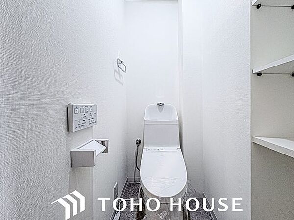 ウォシュレット機能付きのトイレは、収納が付いて実用性も兼ね備えた造り。