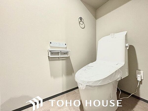 ウォシュレット機能付きのトイレは、収納が付いて実用性も兼ね備えた造り。