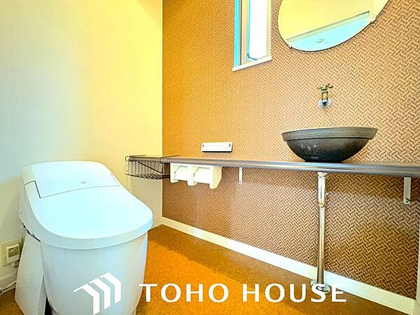 ウォシュレット機能付きのトイレは、収納が付いて実用性も兼ね備えた造り。