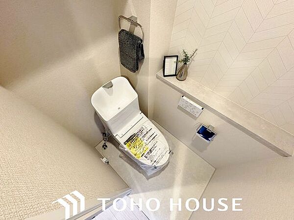 ホワイトを基調とした、清潔感あふれるシンプルなトイレ空間。限られたスペースながらも、お手入れのしやすい床材やクロスが採用されており、日々の掃除がスムーズに行える機能的な造りに仕上がっています。