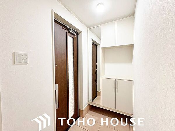 落ち着いた木目調やモダンなカラーの断熱ドア（またはスリットガラス付き仕様）を採用した、品格のある玄関。防犯性の高いダブルロック（または手動・電子錠対応）など、機能面にも配慮された設計です。