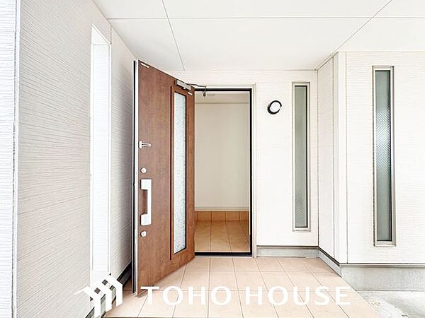 落ち着いた木目調やモダンなカラーの断熱ドア（またはスリットガラス付き仕様）を採用した、品格のある玄関。防犯性の高いダブルロック（または手動・電子錠対応）など、機能面にも配慮された設計です。