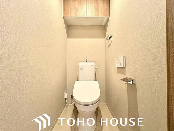 上部に吊り戸棚があり、トイレットペーパーなどの備品を視界に入れず収納できる清潔なトイレです。
