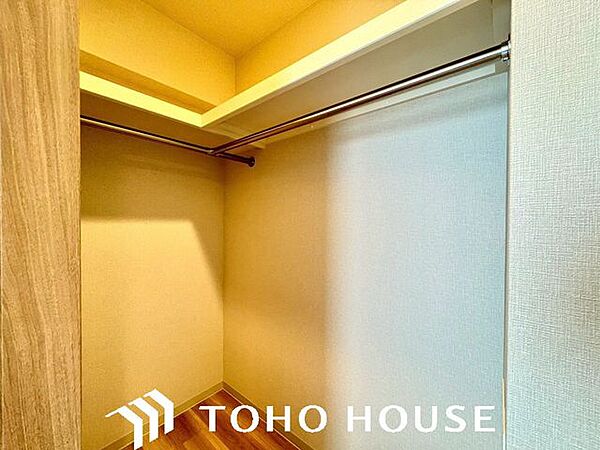 ハンガーパイプと上部棚を備え、衣類や小物を整理整頓しやすいウォークインクローゼットです。
