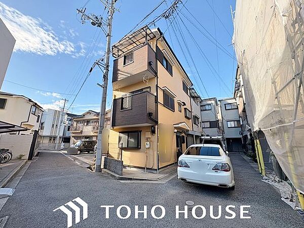 落ち着いたカラーリングと直線的なフォルムが目を引く、モダンな外観デザイン。周囲の環境に調和するスタイリッシュな佇まいで、外壁の質感が建物の堅牢さとクオリティを感じさせる仕上がりです。