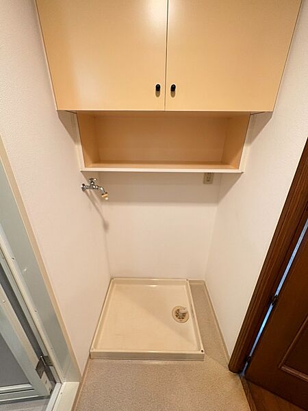 洗濯機置き場／上部に吊戸棚がありタオル等を収納するのに便利です。